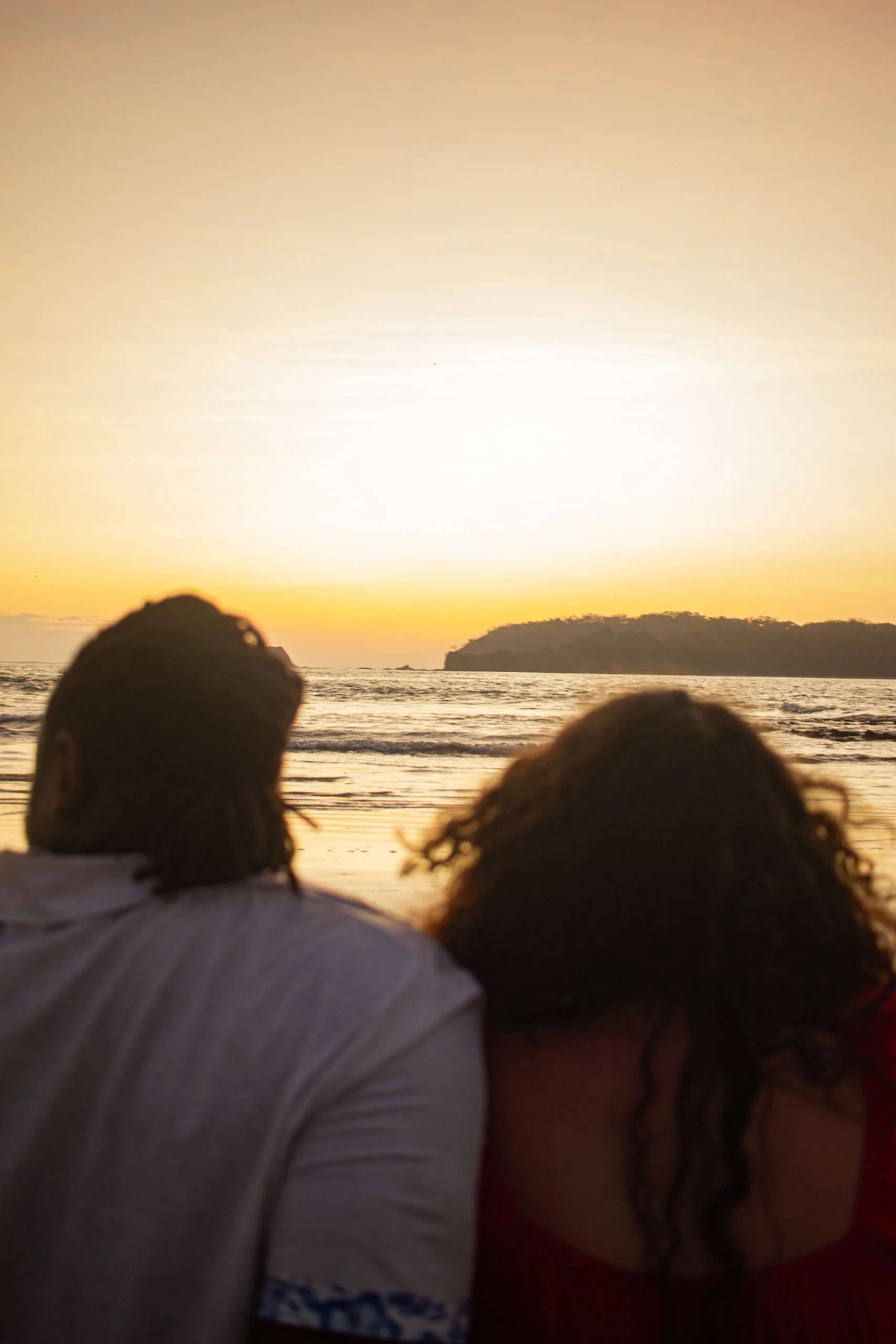 Couple watching the sunset over the ocean in Sámara