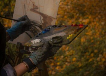 hands paint autumn on canvas