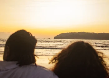 Couple watching the sunset over the ocean in Sámara