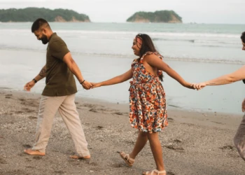 Family walking barefoot along the shoreline in Nosara