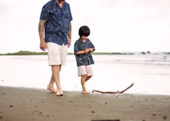 Child playing with parents on a tropical beach in Sámara