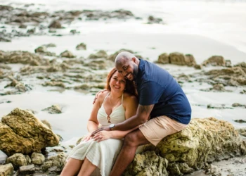Couple posing near the ocean at sunset in Sámara
